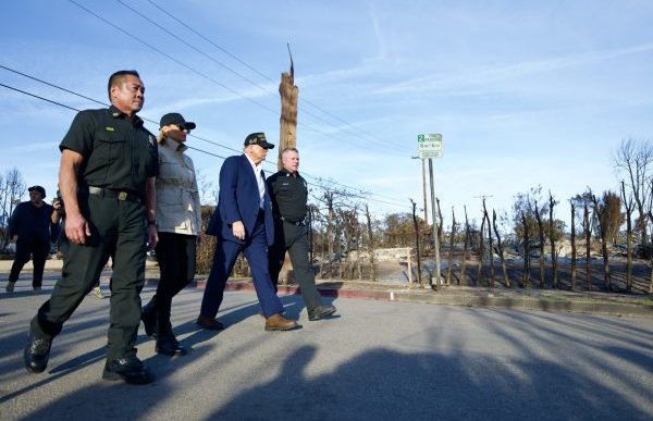 President Donald Trump, third from left, walks with first lady Melania Trump and local officials through a fire-ravaged neighborhood in Pacific Palisades.