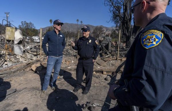 Gov. Gavin Newsom, at left, tours fire destruction in LA County with local first responders.