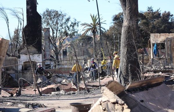 Firefighters sift debris at a property destroyed in the Eaton Fire.