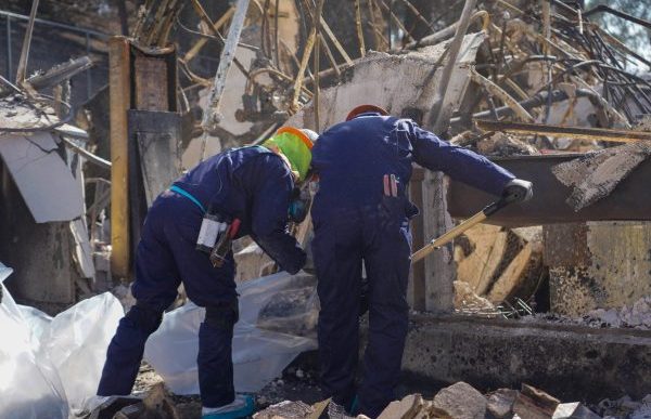 Workers clear fire debris.